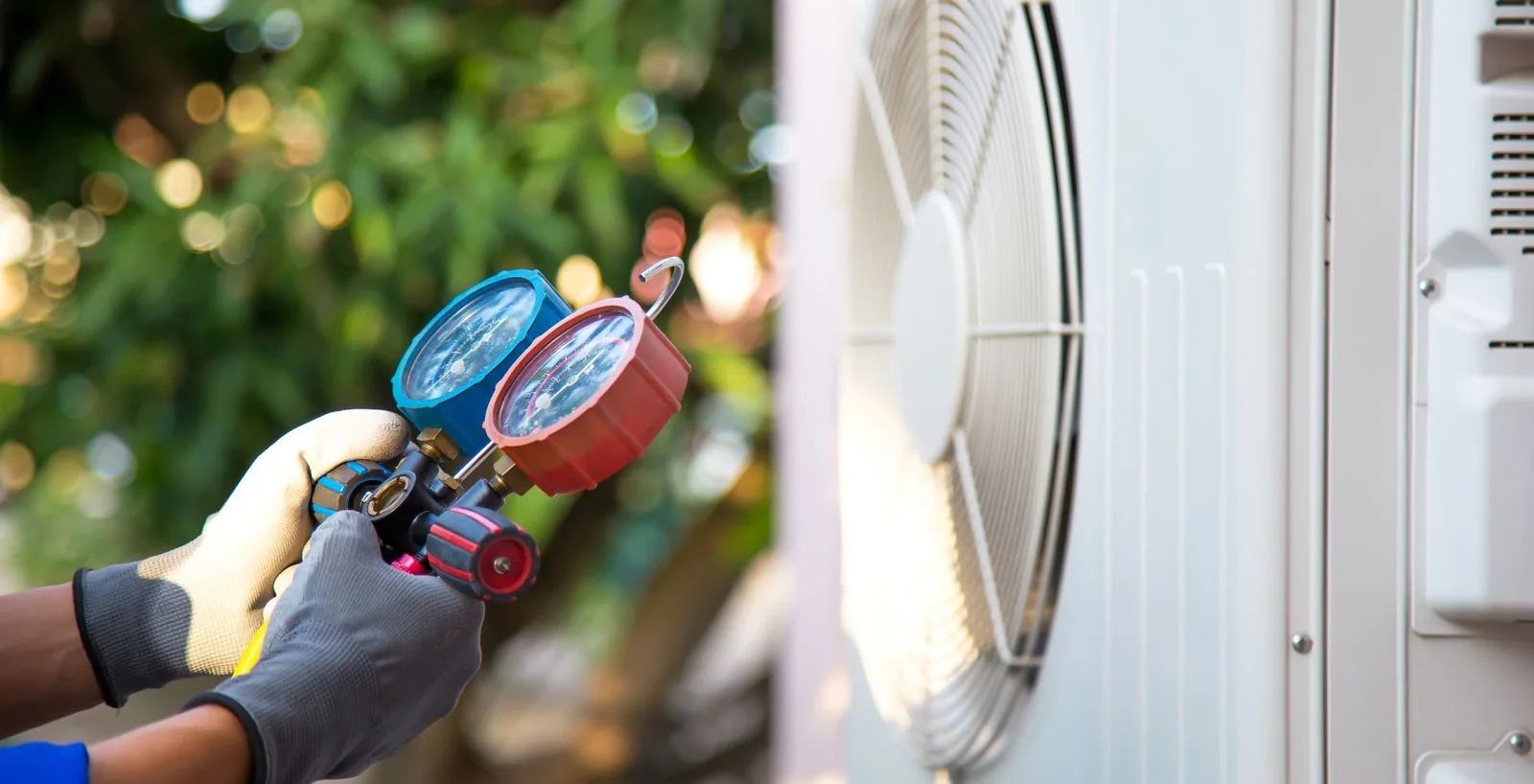 Technician checking air conditioning pressure gauges