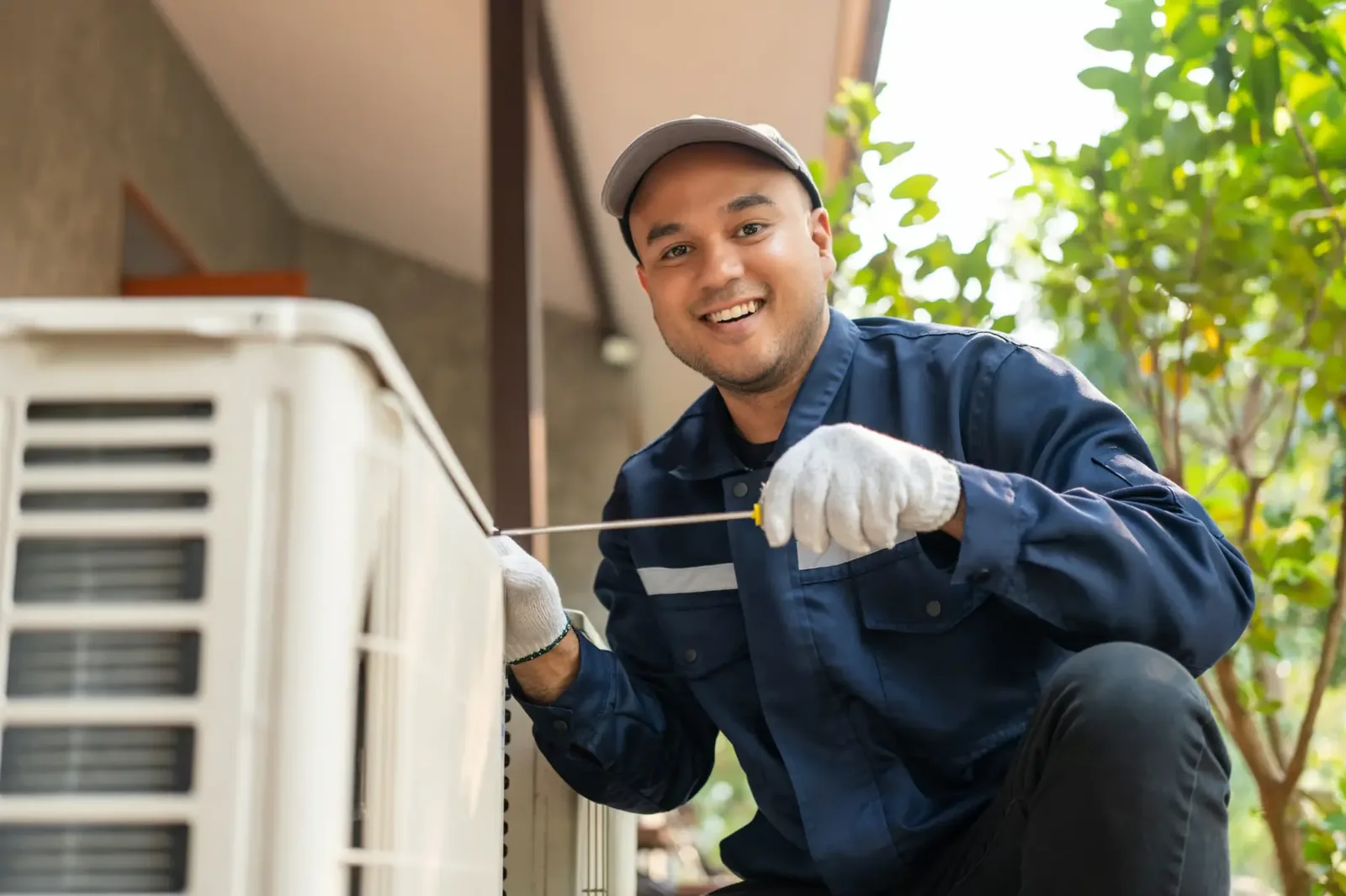 HVAC technician working beside a residential condenser