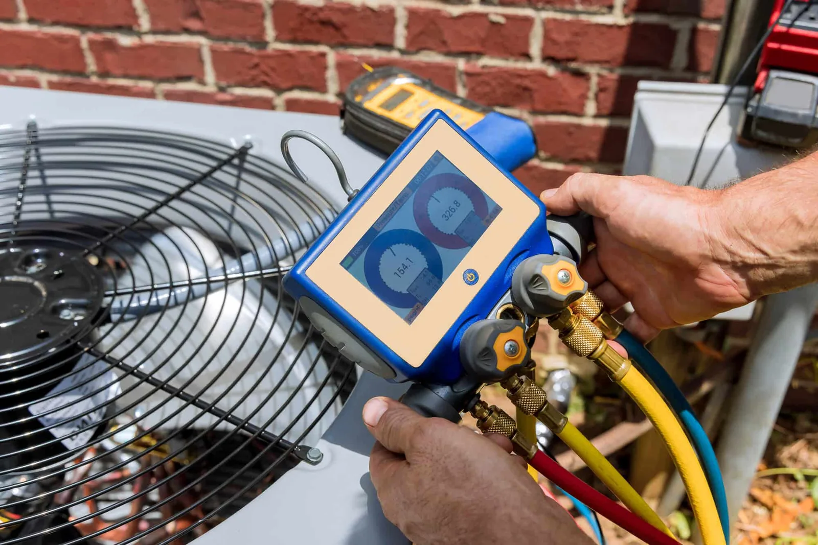 Technician using gauges during HVAC maintenance